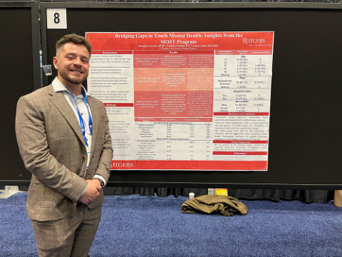 man standing in front of medical presentation poster