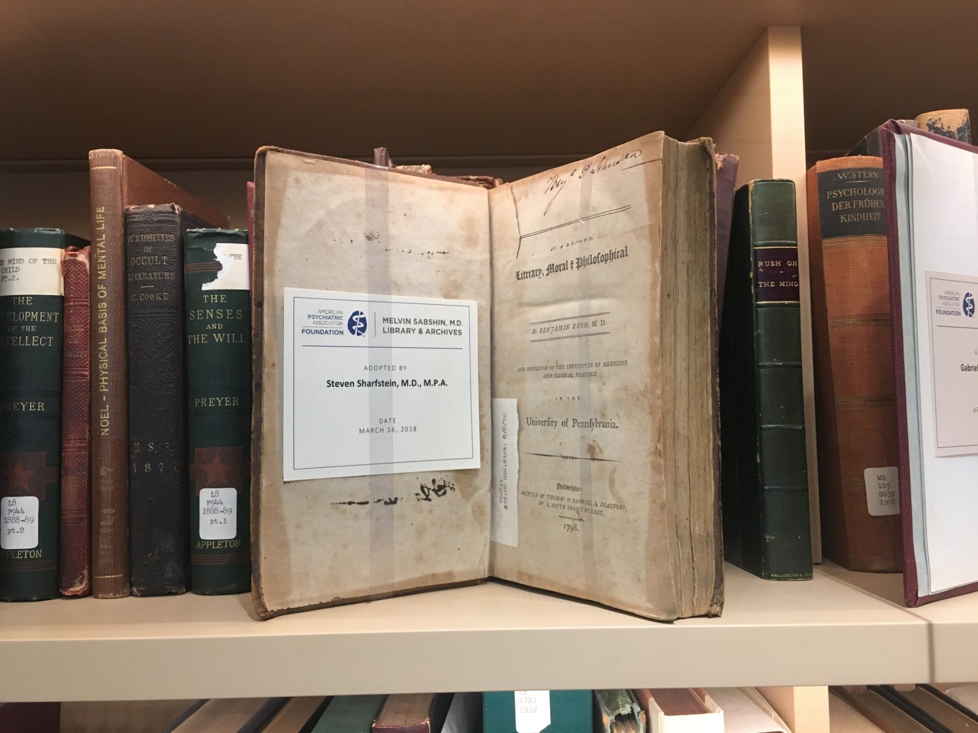 A book open sitting on a library shelf