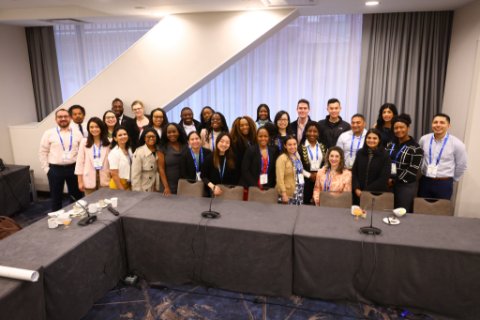 Large group of APA Foundation 2023 fellows posing for a group shot behind a table