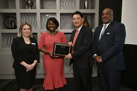 Group of 4 adults and one is being presented an award